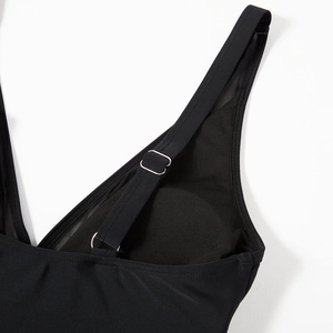 Detail of black swimsuit featuring breathable mesh panels and adjustable silver strap rings