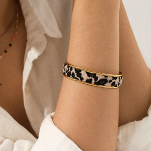 Détail d'un bracelet jonc en acier 18 carats à imprimé léopard porté au poignet