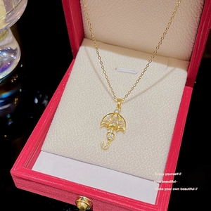 Elegant gold umbrella pendant necklace with pearl inlay and crystals in a red velvet box