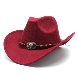 Dettaglio cappello da cowboy bordeaux con fascia intrecciata e ornamento a teschio di toro