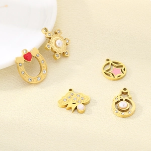 Macro view of five gold DIY stainless steel pendants with star and heart enamel details