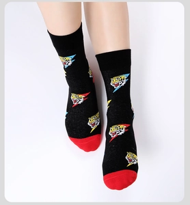 Close-up of black and red crew socks featuring knit tiger head and lightning patterns