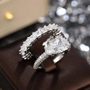 Close-up of sparkling silver sterling pavé eternity ring and square-cut zircon engagement ring