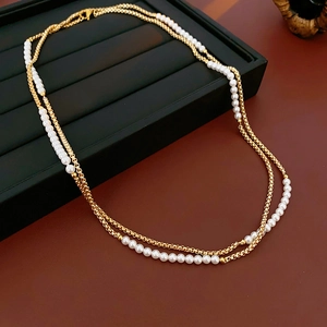 Elegant double-layered gold chain necklace with pearls on a black display tray