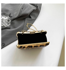 Detail of open leopard evening bag with gold frame, diamond clasp and black velvet lining