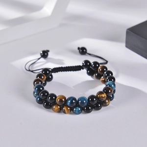 Macro shot of double-layer blue tiger eye and black onyx beads with woven cord detail