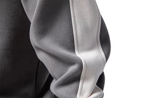Close-up detail of grey and white stitching on high-quality knitted athletic sweatshirt