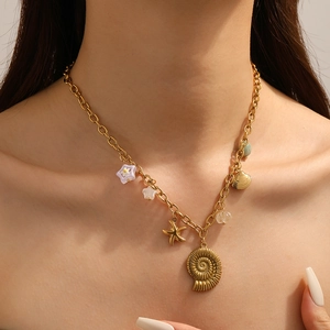 Detail der Goldkette mit Anhängern wie Seestern Seeschnecke Muschel und Blume