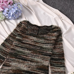 Dettaglio della maglia di un abito autunnale a righe multicolore nei toni della terra