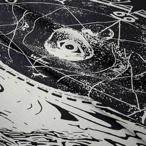 Makroaufnahme von schwarz-weißem Wandteppich mit Auge und geometrischem Muster