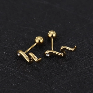Macro detail of snake-shaped gold screw back earrings with sparkling zircon inlay