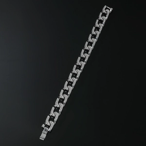 Macro shot of silver iced-out Cuban link chain for men with rhinestones on black background
