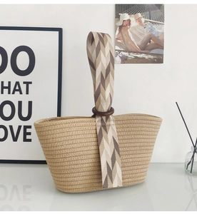 Detail of woven handbag featuring a wooden ring buckle and geometric pattern strap