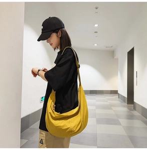 Mannequin portant un sac bandoulière jaune en nylon dans un couloir intérieur moderne