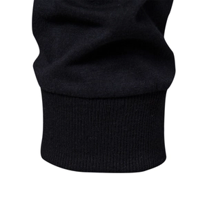Close-up of black cotton knit fabric showing the ribbed cuff detail on a raglan sleeve