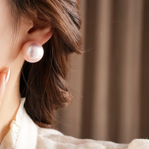 Macro detail of large lavender pearl stud earring with high mirror gloss on model