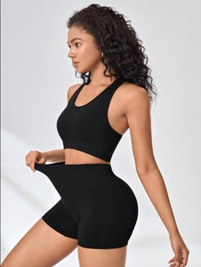 Detail view of seamless high-waist black sports bra and shorts set with textured pattern