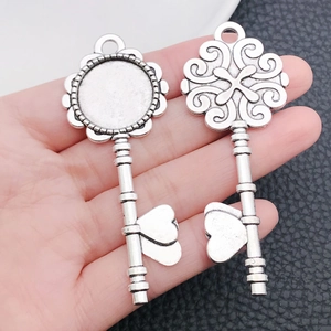 Detail view of antique silver alloy heart key pendants for DIY jewelry making projects