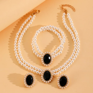 Détail de parure avec collier de perles double rang, bracelet et boucles d'oreilles noires