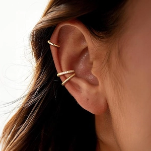 Three-piece gold ear cuff set with diamond accents and twisted rope texture on model ear