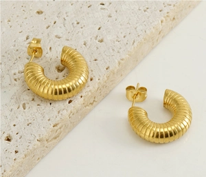 Macro shot of 18k gold plated stainless steel U-shape earrings with ribbed texture design
