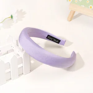 Close-up of lavender padded headband showing handmade label and premium satin texture