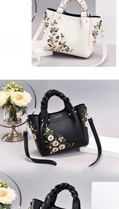 Detail of floral embroidery and woven handles on elegant white and black handbags