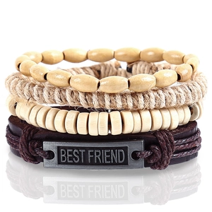 Macro detail of multi-layer woven bracelets with wood beads and Best Friend metal plate