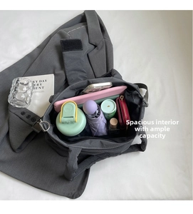 Detail view of the large interior capacity of a grey nylon bow tote bag with daily items