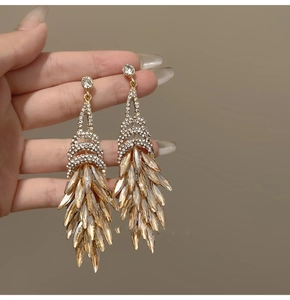 Macro detail of champagne gold tassel earrings with glittering rhinestones and crystals