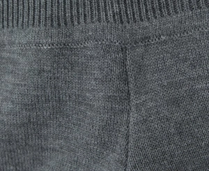 Gros plan sur la maille gris foncé avec poignets côtelés et texture détaillée