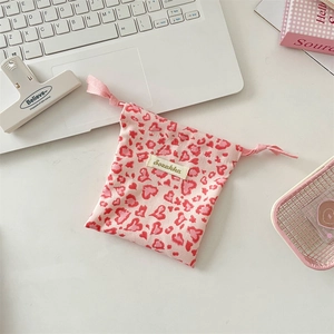 Detail of pink canvas drawstring pouch featuring heart leopard print and brand label