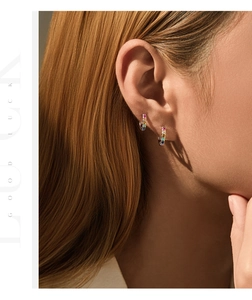Close-up of colorful crystal S925 sterling silver hoop earrings worn by a model