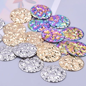 Macro detail of round hammered metal charms in gold, silver, and rainbow plating for DIY