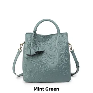Dettaglio della borsa verde menta con motivo a rose in rilievo e nappa decorativa
