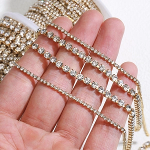 Golden stainless steel rhinestone cup chain in various sizes held for jewelry DIY projects