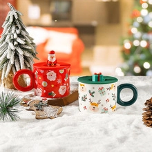 Close-up of red and white Christmas ceramic mugs with Santa and reindeer lids on snow