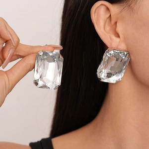 Close-up of oversized square clear crystal earrings with silver claw setting for women