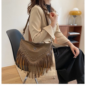 Gros plan sur un sac bohème marron vintage avec franges et rivets métalliques