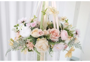 Detailed close-up of floral hanging decoration with pink roses and hanging bead strands