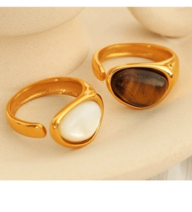Close-up of vintage gold rings with natural tiger eye and white oval gemstone inlay
