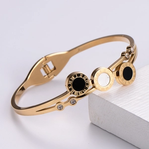 Rose gold roman numeral bangle featuring black shell charms and white zircon accents