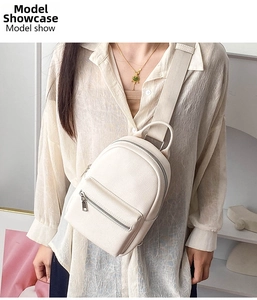 Detailed view of an ivory pebbled leather chest bag shown worn by a fashion model