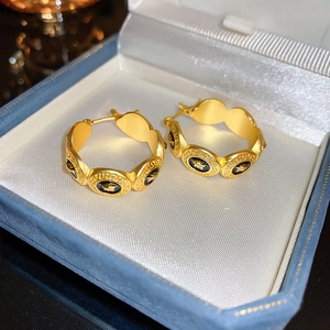 Détail des boucles d'oreilles vintage Medusa avec motif méandre grec et émail noir