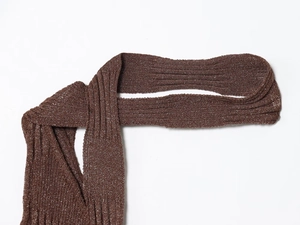 Detail eines kaffeebraunen Strickkleides mit Glitzertextur und geripptem Metallgewebe