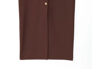 Detail of dark brown crepe midi dress with side slit and round golden button