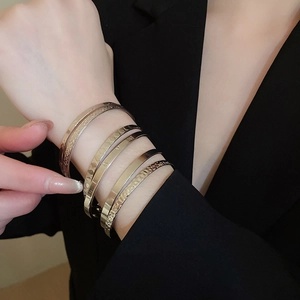 Close-up of gold and silver metal bangles with intricate star patterns and engraved details