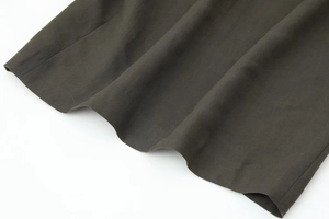 Gros plan détaillé sur la texture du tissu sergé anthracite et les bords de couture