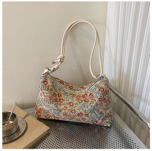 Detail of vintage floral hobo bag with jacquard fabric and knot leather strap