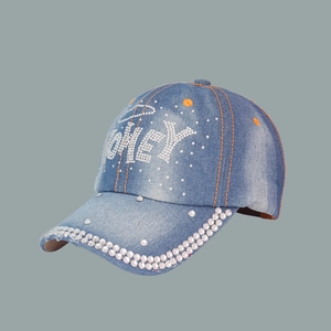 Macro detail of blue denim baseball cap with HONEY rhinestone lettering and stitching